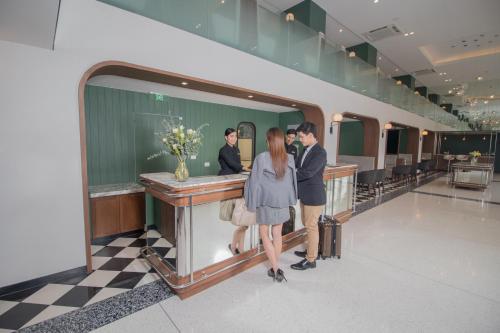 a man and woman standing at a bar in a store at Justice Hotel in Bangkok