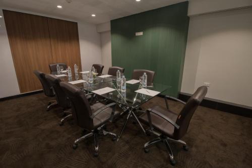 a conference room with a glass table and leather chairs at Justice Hotel in Bangkok