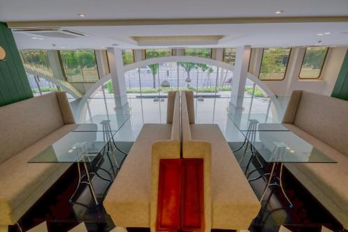 a dining room with a glass table and chairs at Justice Hotel in Bangkok