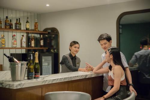a man and a woman standing at a bar at Justice Hotel in Bangkok