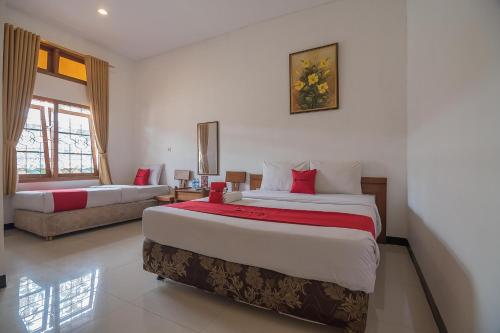 a large bedroom with two beds and a couch at RedDoorz @ Maribaya Street 2 in Bandung