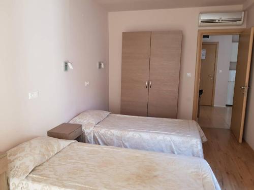 - une chambre avec 2 lits et un placard dans l'établissement Apartment By The Sea, à Pomorie