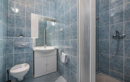 a blue tiled bathroom with a toilet and a shower at Maja Apartment 2 in Funtana
