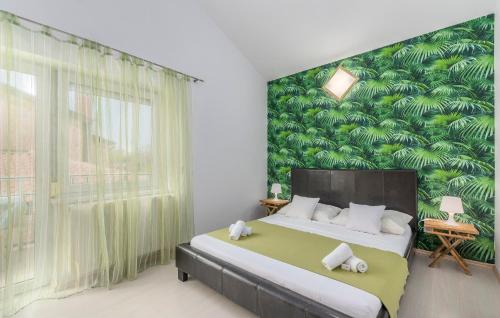 a bedroom with a large bed with a green leafy wall at Maja Apartment 3 in Funtana