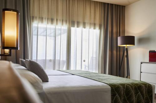 a bedroom with a bed and a large window at Riu Atoll-All Inclusive in Dhaalu Atoll