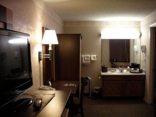 Habitación con baño con lavabo y espejo. en Wetherill Inn, en Kayenta