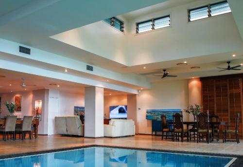 a swimming pool in a room with a table and chairs at Yachtsmans Paradise, Whitsundays in Airlie Beach