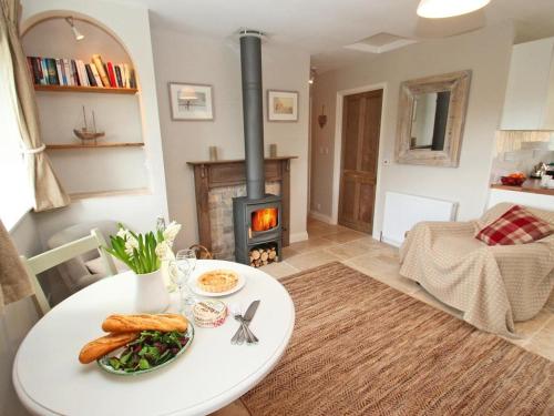 a table with a plate of food and a fireplace at Stocks Barn in Liskeard