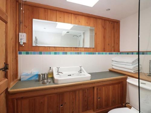 uma casa de banho com um lavatório e um espelho em Halvosso em Penryn