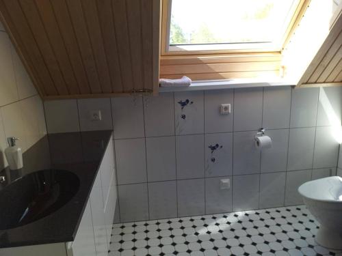 a bathroom with a sink and a toilet and a window at Kiviranna puhkemajad in Suure-Rakke