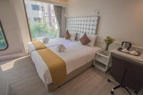 a bedroom with a large bed with two teddy bears on it at Justice Hotel in Bangkok