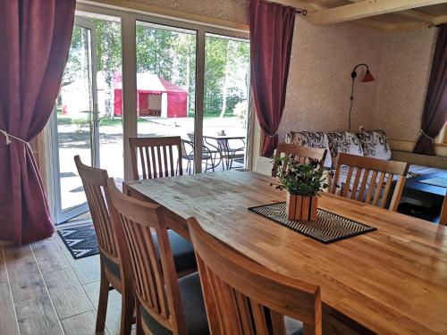 a dining room with a wooden table and chairs at Kiviranna puhkemajad in Suure-Rakke