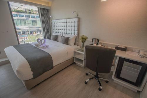 a bedroom with a bed and a desk and a computer at Justice Hotel in Bangkok