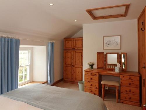 um quarto com uma cama, uma cómoda e um espelho em Halvosso em Penryn
