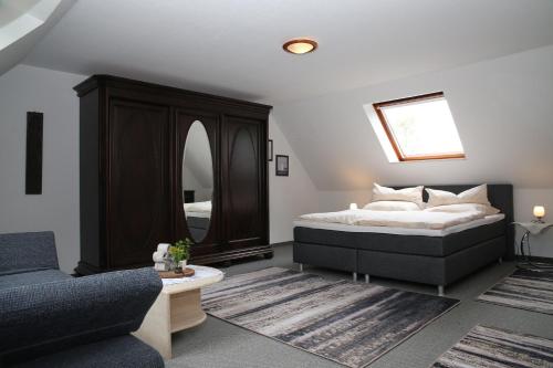 una camera con letto, divano e specchio di Ferienwohnung am Schwarzen Wehl a Dorum-Neufeld