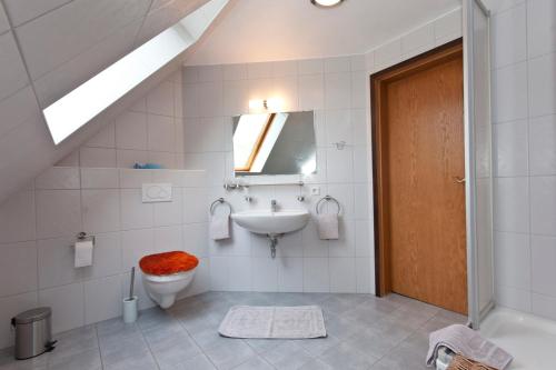 bagno con lavandino, servizi igienici e specchio di Ferienwohnung am Schwarzen Wehl a Dorum-Neufeld