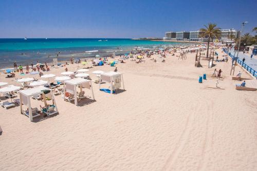 a beach with a lot of people and the ocean at Hotel Marítimo Urban in Alicante