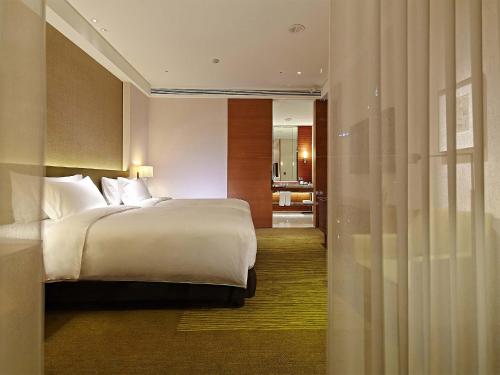 a bedroom with a bed and a dresser at Eslite Hotel in Taipei