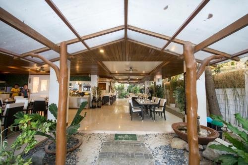 a restaurant with a large wooden ceiling and tables and chairs at Sur Beach Resort Boracay in Boracay