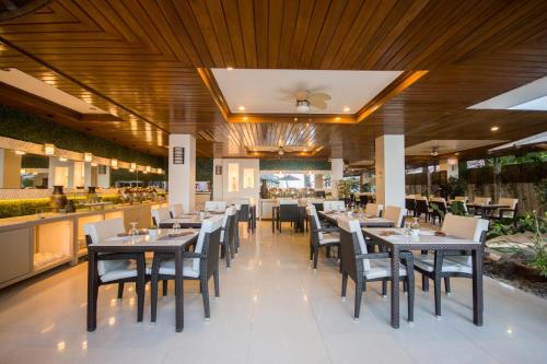 a dining room with tables and chairs in a restaurant at Sur Beach Resort Boracay in Boracay