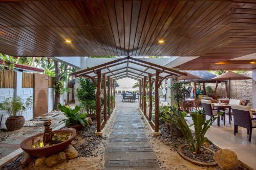 an outdoor patio with a wooden pergola at Sur Beach Resort Boracay in Boracay