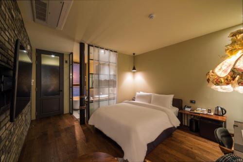 a bedroom with a large white bed and a chandelier at Hotel March in Daejeon