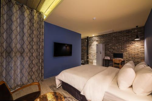 a bedroom with a white bed and a blue wall at Hotel March in Daejeon