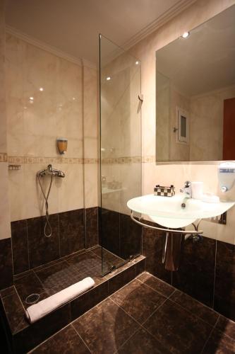 a bathroom with a sink and a shower at Anastazia Luxury Suites & Spa in Athens