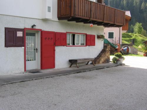 un edificio con porte rosse e una panca davanti di Casa Simion a Mezzano