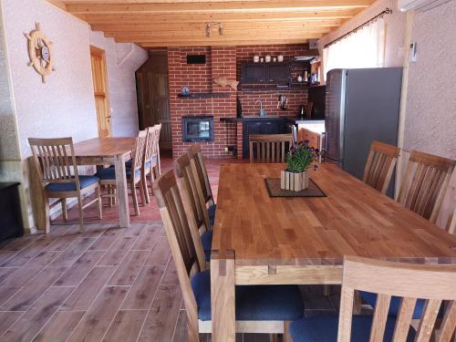 a kitchen and dining room with a wooden table and chairs at Kiviranna puhkemajad in Suure-Rakke