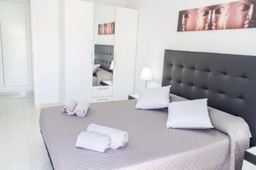 Un dormitorio con una cama con toallas blancas. en Apartamento Montroig 2, en Sitges