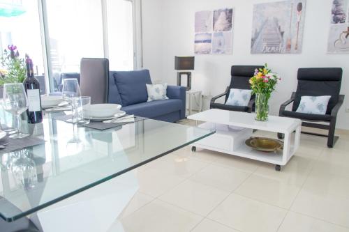 sala de estar con mesa de cristal y sillas en Apartamento Montroig 2, en Sitges