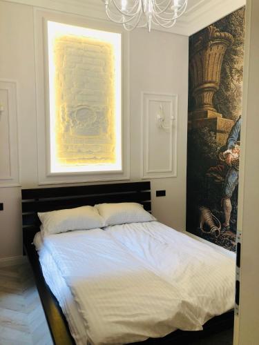 a bedroom with a bed with a painting on the wall at VIP apartment history in Lviv