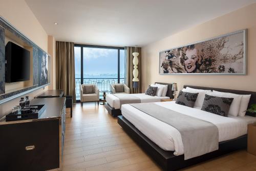 a hotel room with two beds and a television at Way Hotel Pattaya in North Pattaya