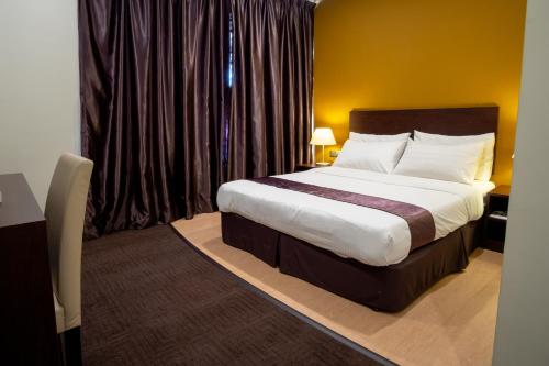 a bedroom with a large bed in a hotel room at Orkid Inn Mahkota Cheras in Kampong Perimbun