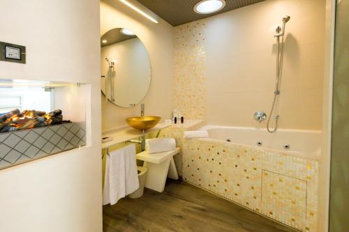a bathroom with a tub and a sink and a toilet at Hotel & Spa Princesa Munia in Oviedo