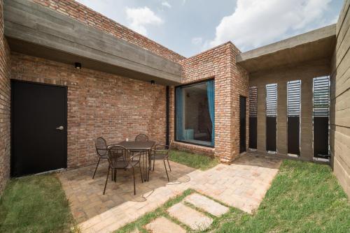 a patio with a table and chairs next to a brick wall at Hotel March in Daejeon