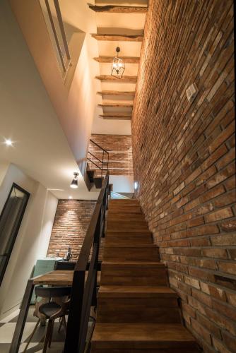 a brick wall and stairs in a room with a table at Hotel March in Daejeon