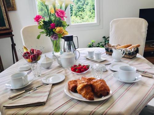 una mesa con un plato de comida y flores en ella en La maison d'Hera, en Saint-Yrieix-la-Perche