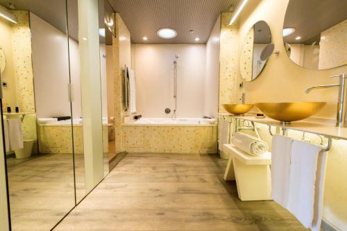 a bathroom with two sinks and a tub at Hotel & Spa Princesa Munia in Oviedo