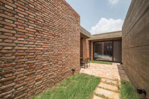 a brick wall next to a patio with grass at Hotel March in Daejeon