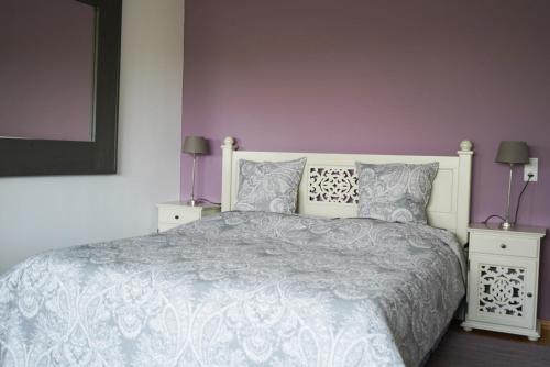 a bedroom with a white bed with purple walls at Ferienwohnung Zeilfelder in Hirschberg an der Bergstraße