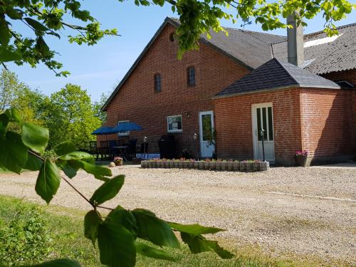 een rood bakstenen gebouw met een witte deur bij Kyndestoft Bed & Breakfast in Holstebro