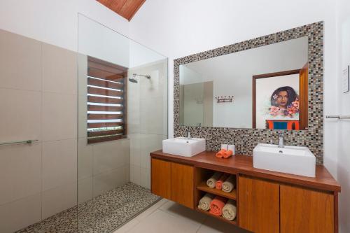 Baño con 2 lavabos y espejo en Private Holiday House, en Tangangge