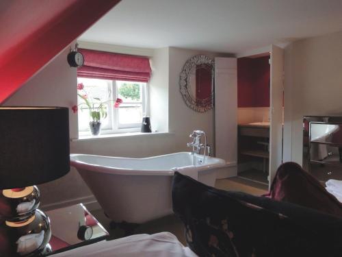 Un baño con bañera y ventana. en Maristow Barton, en Plymouth