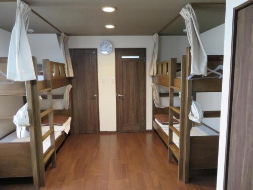 Cette chambre comprend 4 lits superposés et un couloir. dans l'établissement Azalea, à Osaka