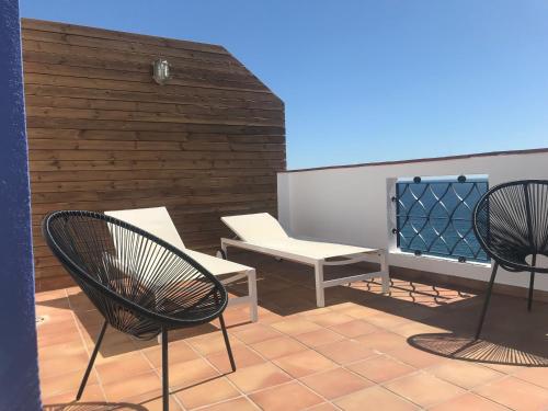 two chairs and a bench on a patio at Hotel Els Pins in Platja  d'Aro