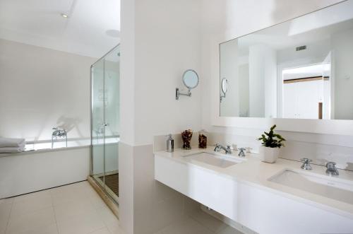 a white bathroom with two sinks and a mirror at Relais Blu in Massa Lubrense