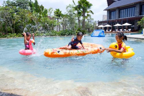 three children are playing in a swimming pool at Pullman Ciawi Vimala Hills Resort in Bogor