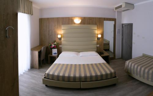 a hotel room with a bed and two beds sidx sidx sidx at Hotel Myosotis in Riccione